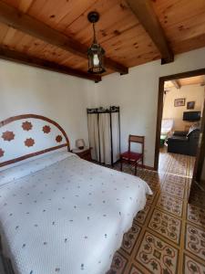 a bedroom with a white bed with a wooden ceiling at Las Peonías Casa Rural in Almiruete