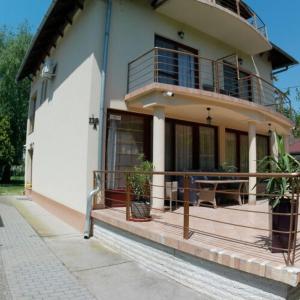 une maison avec un balcon et une table sur la terrasse couverte dans l'établissement Balatoni Aranyparti Apartmanok, à Siófok