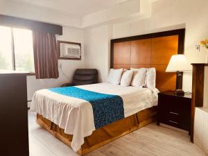 a hotel room with a bed and a chair at Travelodge by Wyndham Valleyfair Shakopee in Shakopee +77 photos
