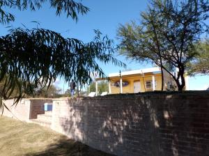 een geel huis staat achter een bakstenen muur bij Cabaña en Ibicuy in Ibicuy