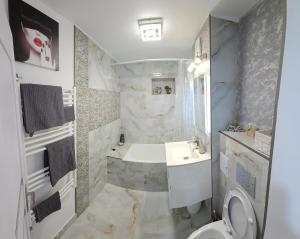 プロイェシュティにあるChique Apartamentの浴槽、洗面台、トイレを備えたバスルーム +15枚の写真