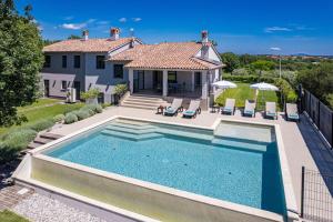 ein Bild eines Swimmingpools vor einem Haus in der Unterkunft Villa Monte Uliveto in Pula