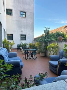 eine Terrasse mit blauen Stühlen, einem Tisch und einem Gebäude in der Unterkunft Hotel Trindade Coelho in Mogadouro