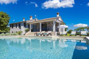 eine Villa mit einem Swimmingpool vor einem Haus in der Unterkunft Villa Monte Uliveto in Pula