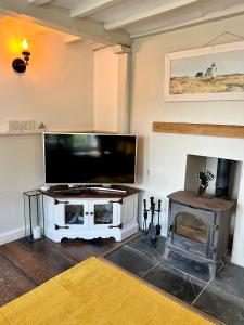 TV in/ali zabaviščno središče v nastanitvi Cosy Coastal 2-Bedroom Cottage with Hot Tub and Log Burner