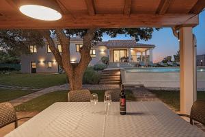 eine Flasche Wein auf einem Tisch vor einem Haus in der Unterkunft Villa Monte Uliveto in Pula