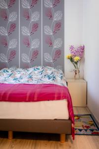 Schlafzimmer mit einem Bett mit rosa und weißer Tapete in der Unterkunft Apartman Milka in Slunj