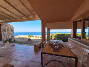 a patio with a table and chairs and the ocean at villetta costa paradiso in Costa Paradiso