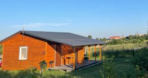 a house with a solar roof and a deck at Łąkowa Dolina - domek letniskowy in Supraśl +12 photos