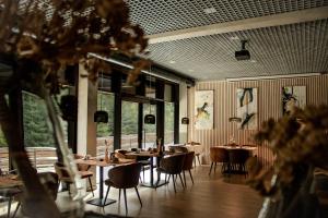 a dining room with tables and chairs and windows at DAS ERZ Medical Spa & Hotel in Crottendorf +54 photos