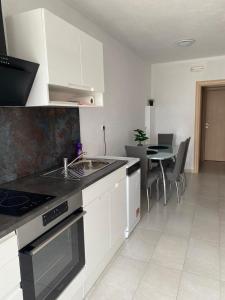 a kitchen with a sink and a stove top oven at Apartment Tina, Modern, Private SeaView Outdoor Terrace, BBQ, close to beach, 2 bedrooms in Trogir