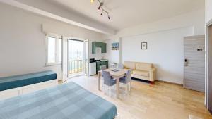a bedroom with a bed and a table and a couch at La casa di Tina in Briatico