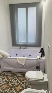 ein weißes Badezimmer mit Badewanne und Toilette in der Unterkunft Rosarias Rooms in Manfredonia