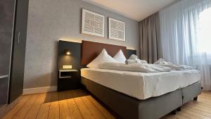 a bedroom with a large bed with white sheets at JUNIK Apartments Oberhausen No º11 in Oberhausen