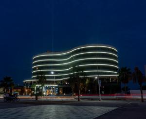 un edificio con una fachada iluminada por la noche en FASQ Hotel en Nuakchot