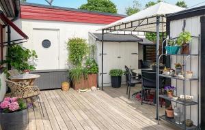 un patio avec une table et des plantes en pot dans l'établissement Cozy Home In Borgholm With Wifi, à Borgholm
