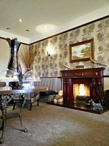 a living room with a fireplace and a table at Lauriston Hotel in Ardrossan