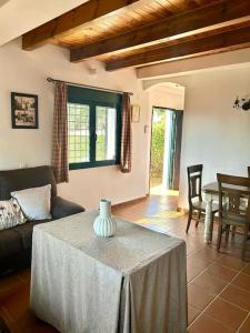 Una sala de estar con una mesa con un jarrón encima. en Hispalis villa en Aracena, en La Umbría