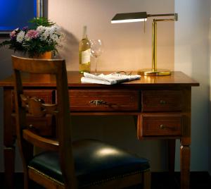 - un bureau avec une lampe et une bouteille de vin dans l'établissement Apartmenthaus Feuerbach, à Leipzig