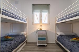 Un dormitorio con dos literas y una ventana. en Parisito Sancti Petri, en Chiclana de la Frontera 44 fotos más