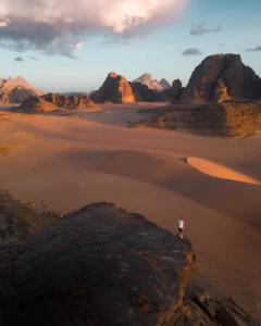 a person standing on a rock in the desert at Bedouin bunch camp in Wadi Rum