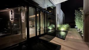 uma casa de vidro com uma piscina reflectora à noite em Murrae Loft em La Morra