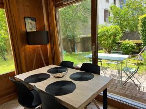een tafel en stoelen in een kamer met een raam bij Appartement Chamonix-Mont-Blanc, 2 pièces, 4 personnes - FR-1-343-241 in Chamonix-Mont-Blanc