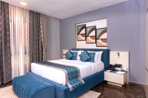 FASQ Hotel في نواكشوط: غرفة نوم بسرير كبير وأريكة زرقاء