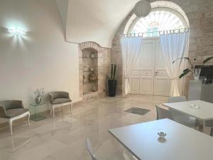 a living room with a large door and a table and chairs at AuGuStea in Sannicandro di Bari