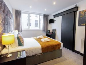 a bedroom with a large bed with a yellow blanket at Sinclair's Rooms in Southport