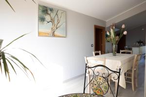 a dining room with a table with a vase of flowers at Tenuta Albachiara in Naso