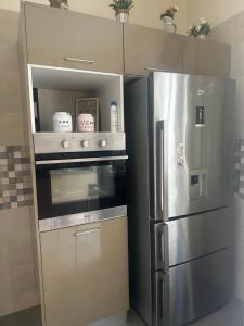 a kitchen with a refrigerator and a stove at Superbe duplex avec jardin in Al Karm