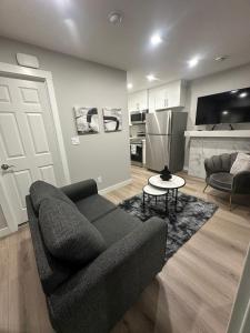 Una sala de estar con un sofá y una cocina. en Luxurious Home in NW Calgary, Free Parking, High Speed Internet, Near Grocery and Airport, en Calgary