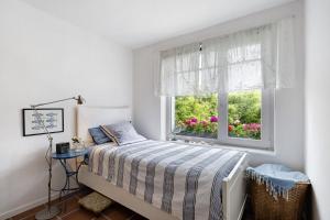 a bedroom with a bed and a window with pink flowers at Ferienhaus Karinella in Gronenberg
