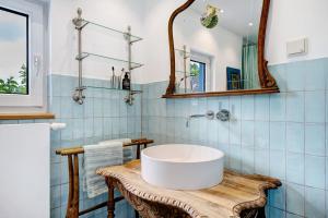 a bathroom with a white sink and blue tiles at Ferienhaus Karinella in Gronenberg