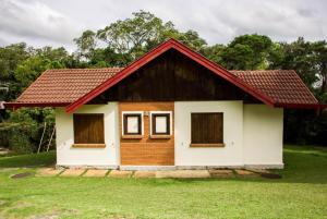 ein kleines Haus mit rotem Dach in der Unterkunft Villa Rural in Campos do Jordão
