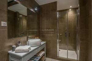 a bathroom with a shower and a sink and a mirror at Le Relais du Beffroi & SPA in Saint-Riquier +57 photos