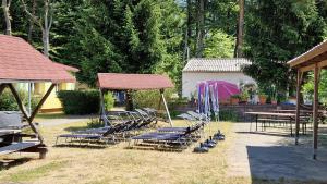 a group of lounge chairs and a table and a pavilion at Pension Stechlinsee in Neuglobsow