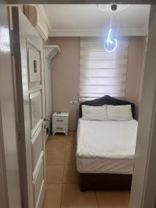 a small bedroom with a bed and a light at Asya Hotel in Konya
