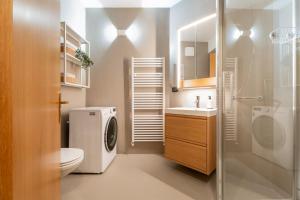 a bathroom with a toilet sink and a washer at Casa Clara, old town experience in Riva del Garda