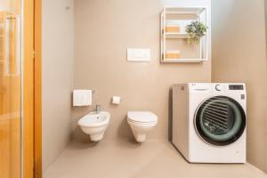 a bathroom with a washing machine and a toilet at Casa Clara, old town experience in Riva del Garda +19 photos