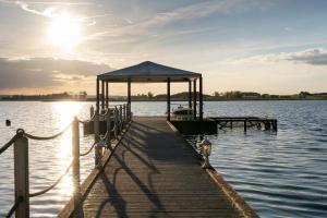 a dock with a gazebo on a body of water at Panorama Seeresort & Spa in Warnitz
