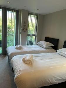 ニューキーにあるModern apartment, Fistral beachのベッドルーム1室(タオル付)のベッド2台