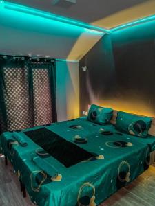 a green bed in a room with a blue light at Dreams Rooms in Dušanovac (historical)