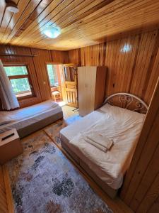 a room with two beds and a refrigerator in it at Uzungöl Merkez Konut 3 Banyo-WC 3 Balkon in Uzungol