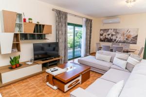 ein Wohnzimmer mit einem Sofa und einem TV in der Unterkunft Xhorxhi villa in Ksamil