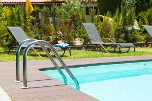two chairs and a swimming pool in a yard at Hotel Rural El Refugio in Tejeda