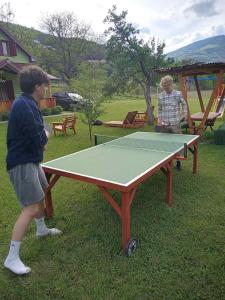 a boy standing next to a ping pong table at Household Nikolic - Andrijevica, Montenegro in Andrijevica