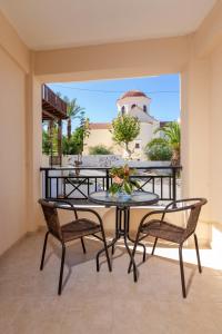 patio con mesa y sillas en el balcón en Castello Apartments, en Panormos Rethymno