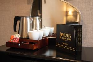 a table with a coffee pot and cups on it at Sinclair's Rooms in Southport